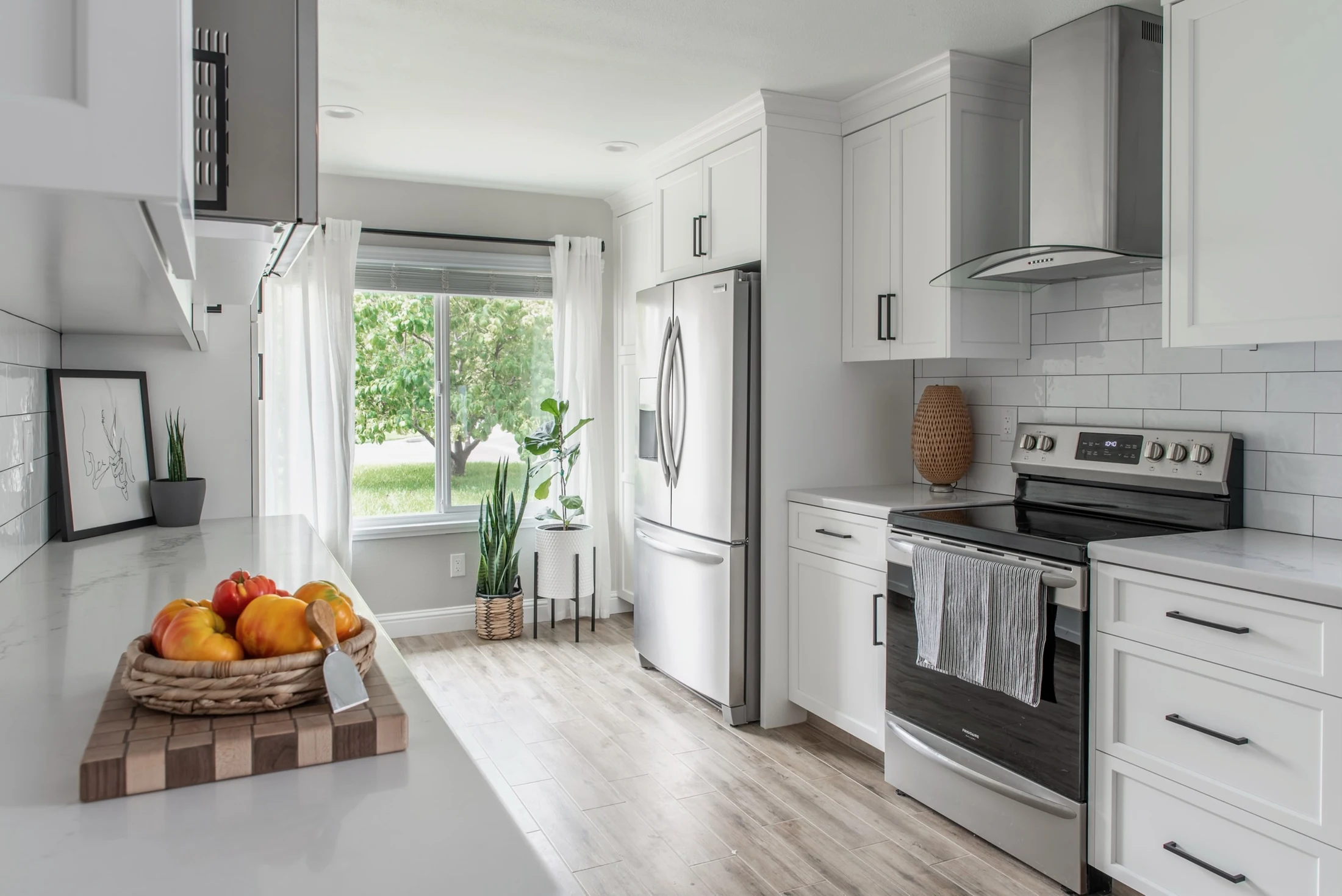 Completed white kitchen viewed toward range and window