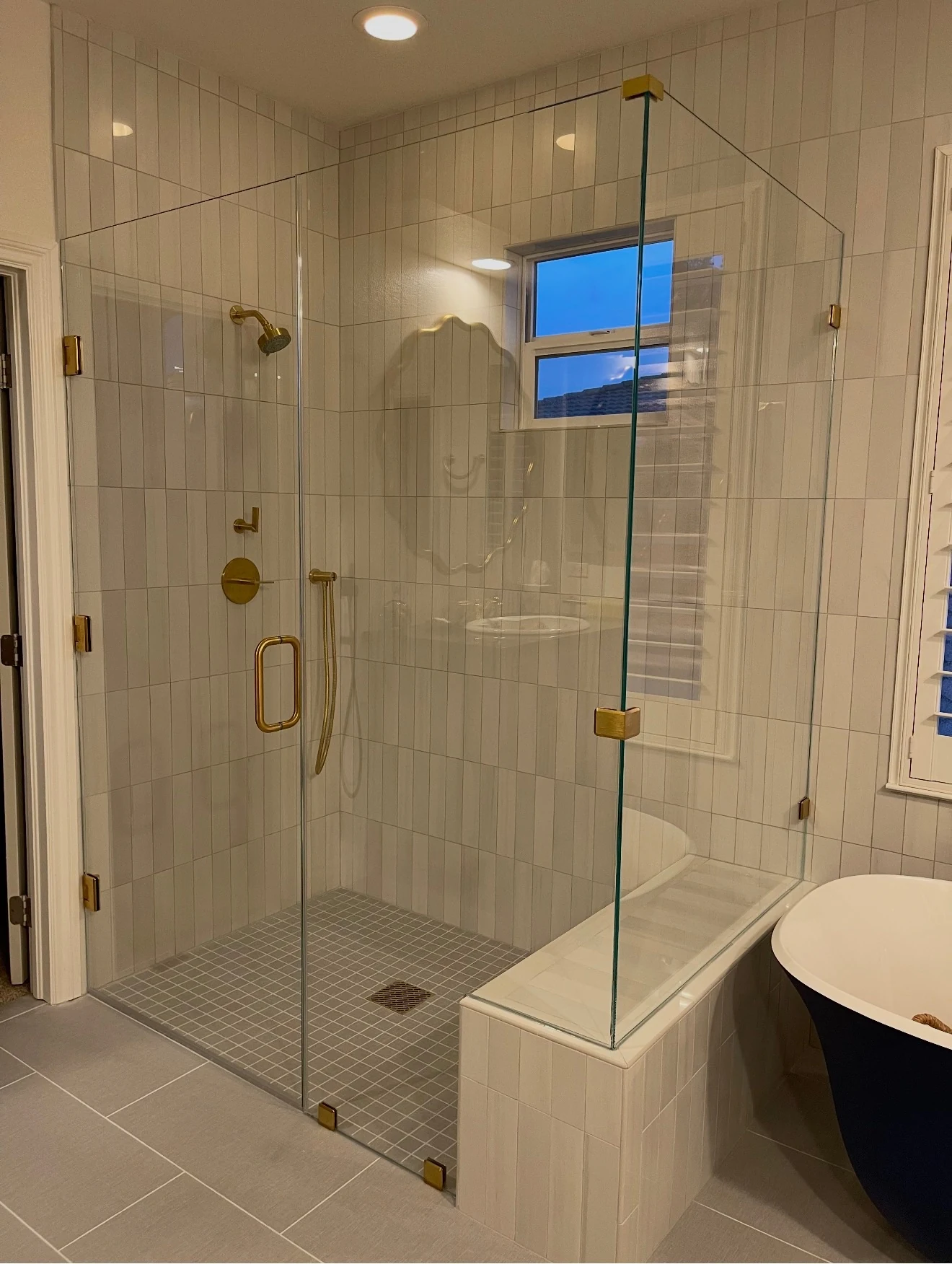 Custom shower with brass fixtures and frameless glass